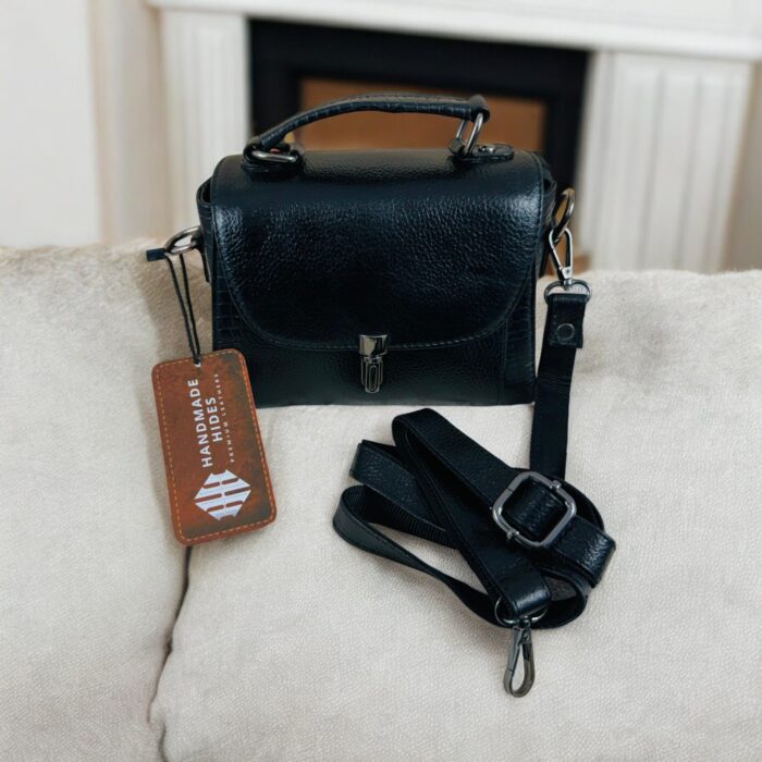Elegant black leather handbag for women with a secure flap closure, adjustable detachable strap, and high-quality metal accents. Handmade from full-grain leather