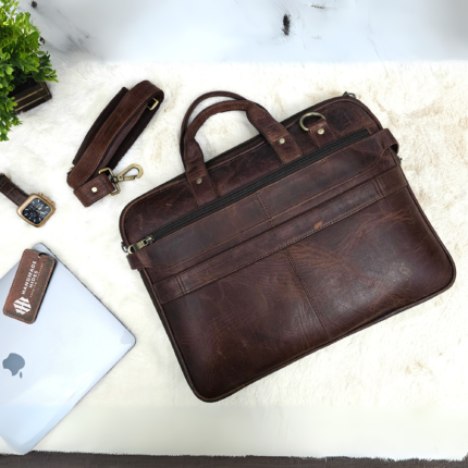 Handmade leather laptop bag in vintage brown with detachable strap, designed for professionals, featuring spacious compartments and premium craftsmanship.