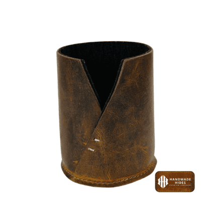 Rustic leather pen holder on a desk.