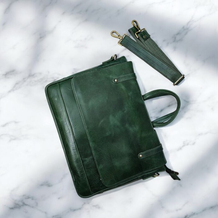 Handmade Green Leather Laptop Bag displayed with office essentials
