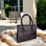 dark brown crocodile-embossed leather handbag with a structured silhouette.