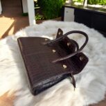 dark brown crocodile-embossed leather handbag with a structured silhouette.