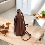 Handmade brown leather backpack with quilted stitching and a front buckle pocket
