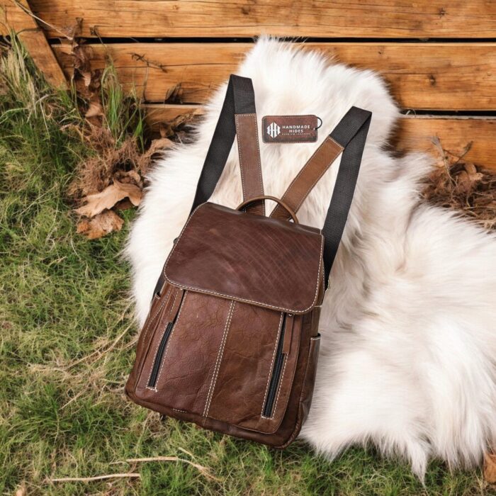 Handcrafted full-grain brown leather backpack with quilted stitching and a front buckle pocket.