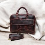 Premium full-grain leather laptop bag for professionals, handcrafted with spacious compartments, durable metal zippers, and adjustable strap for versatile carry