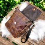 Handmade brown leather crossbody bag featuring a rustic finish, adjustable leather strap, secure flap and zipper closure, and spacious compartments.