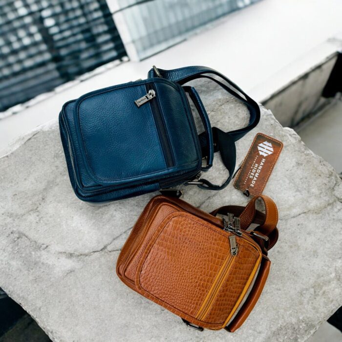 Handmade crocodile-embossed blue leather crossbody bag with an adjustable strap, multiple compartments, and a secure closure for everyday essentials