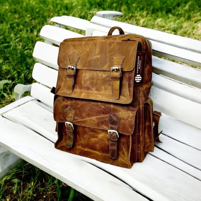 Handmade genuine leather backpack in a vintage brown finish, featuring adjustable straps and premium craftsmanship