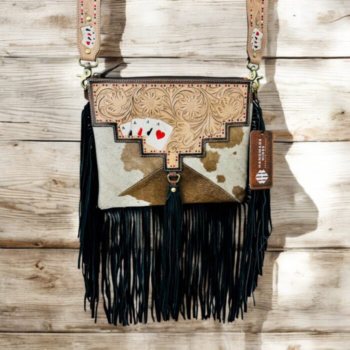 Luxury hair-on leather crossbody bag with tooled leather accents and fringe details