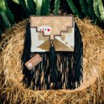 Luxury hair-on leather crossbody bag with tooled leather accents and fringe details