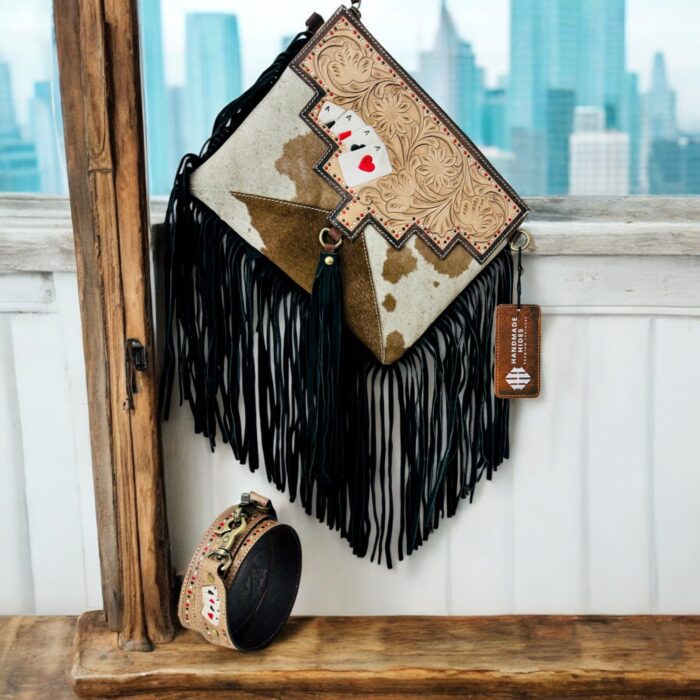 Luxury hair-on leather crossbody bag with tooled leather accents and fringe details