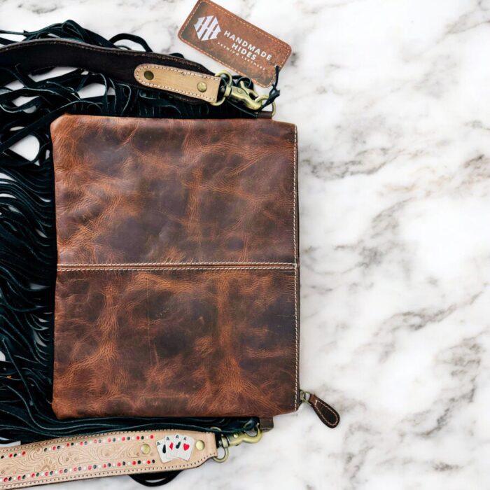 Luxury hair-on leather crossbody bag with tooled leather accents and fringe details