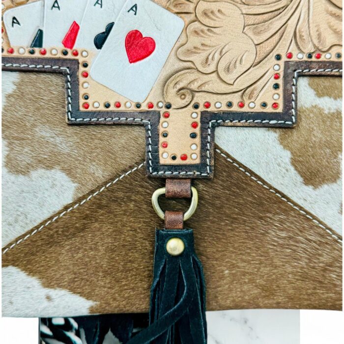 Luxury hair-on leather crossbody bag with tooled leather accents and fringe details