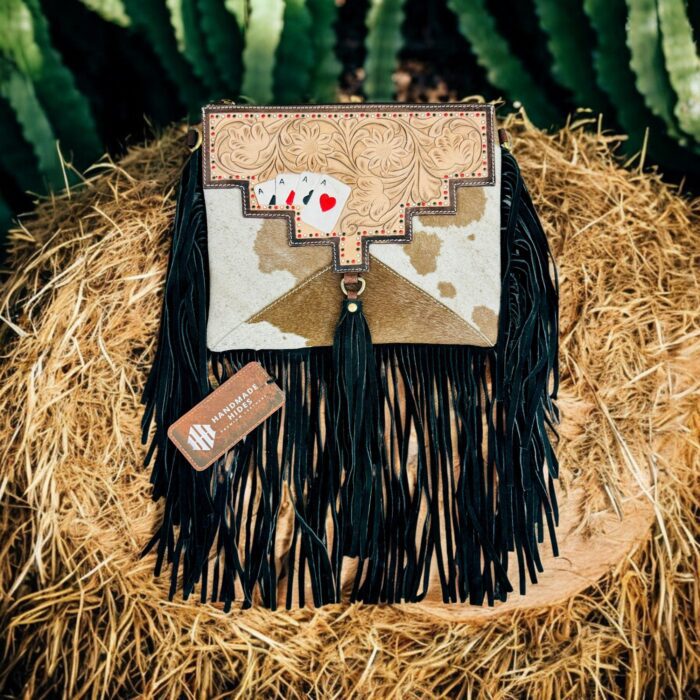 Luxury hair-on leather crossbody bag with tooled leather accents and fringe details