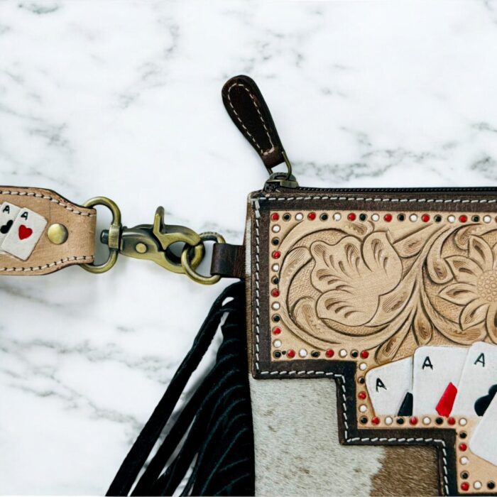Luxury hair-on leather crossbody bag with tooled leather accents and fringe details